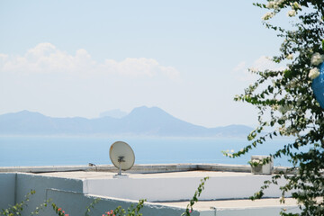 Fototapeta premium White Building with Blue Shutters and Bougainvillea in Mediterranean Town