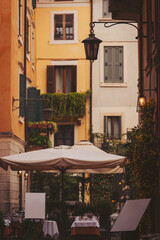 Fototapeta premium Charming alleyway restaurant under a warm lantern glow in a vibrant cityscape