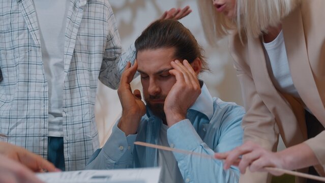 Angry annoyed irritated casual informal business team arguing about papers in startup in office Caucasian sad man feeling headache migraine multiethnic colleagues conflict quarrel disagreement talk
