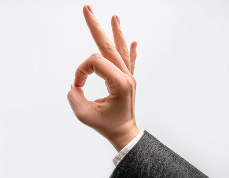 a single hand making the ok gesture with fingers extended against a plain white background studio shot