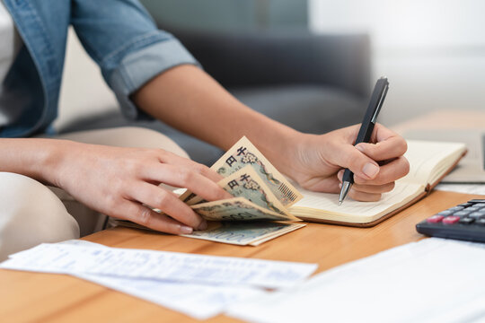 Economic inflation problem concept with close-up hands of woman counting cash money and calculating income for monthly expenses, financial crisis and home budget