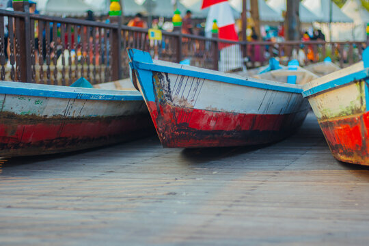 Close-up of colorful wooden canoes docked on a wooden pier board