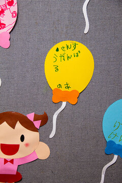 Colorful balloons and cartoon figures decorate a classroom wall for a special event