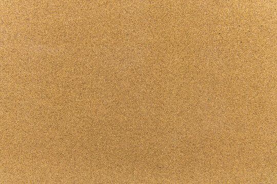 Sand texture fills the view showing fine grains in the sunlight at the beach