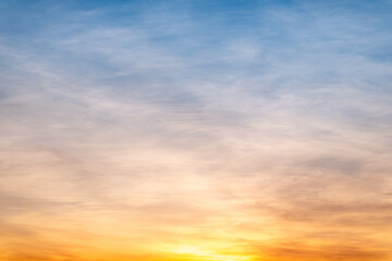 Obraz premium Sky sunset,Beautiful sunrise sky with vibrant gradient orange and gold colors and soft blue, Clear atmosphere with wispy clouds. Peaceful, perfect for background and copy space, High resolution images