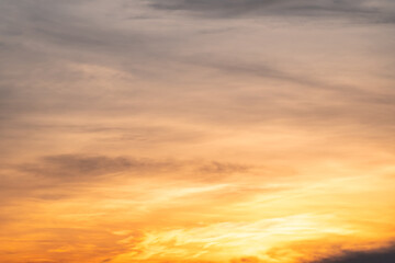 Fototapeta premium Sky sunset,Beautiful sunrise sky with vibrant gradient orange and gold colors and soft blue, Clear atmosphere with wispy clouds. Peaceful, perfect for background and copy space, High resolution images