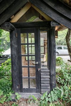 Rustic Wooden Telephone Booth Surrounded by Greenery Outdoors
