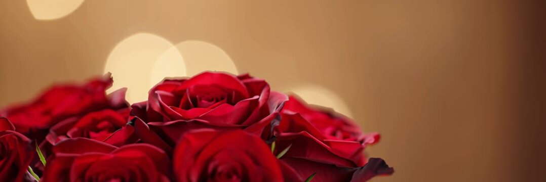 Red rose bouquet on warm bokeh background, romance concept for Valentine website banner with copy space for text