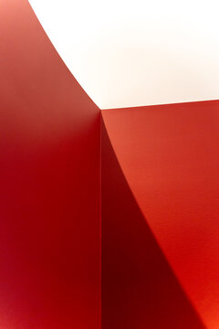 Abstract minimalist architecture featuring striking red walls, geometric shadows, and clean copy space. Ideal for modern B2B conceptual backgrounds.