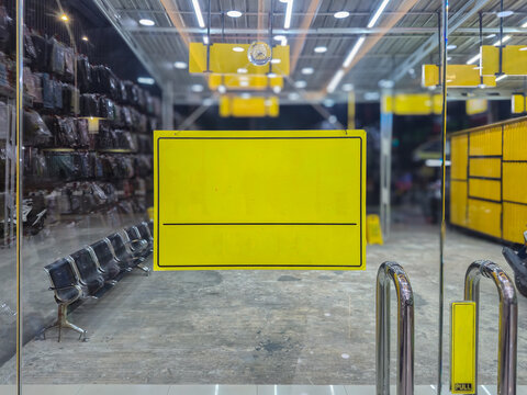 ​Blank Yellow Sign Board Mockup on Glass Door Entrance of Retail Shop Store Front for Text Copy Space
