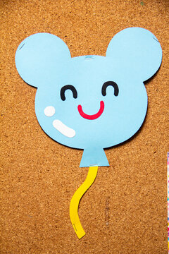 Craft project of a blue balloon shaped like a mouse with a smiling face