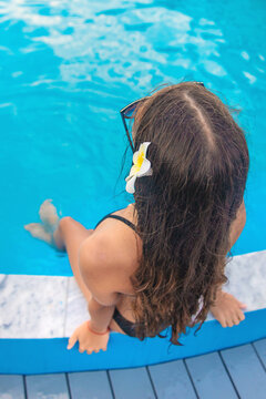 A teenage girl relaxing by the pool. Selective focus.