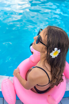 A teenage girl relaxing by the pool. Selective focus.
