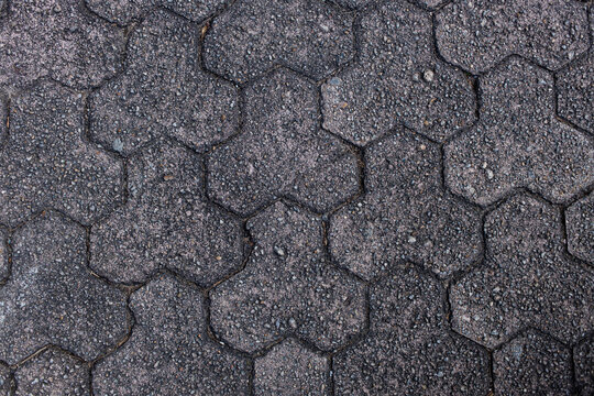 Hexagonal pattern on walking path seen at city park during daylight hours