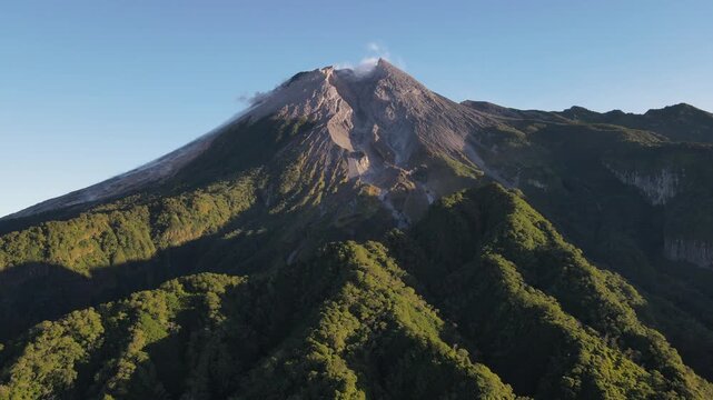 Scenic Aerial Footage of Merapi Volcano with Lush Tropical Forested Slopes During Morning Under a Clear Sky, Vibrant and Wonderful Mountain Scenery of Volcanic Landscape in Yogyakarta, Indonesia.