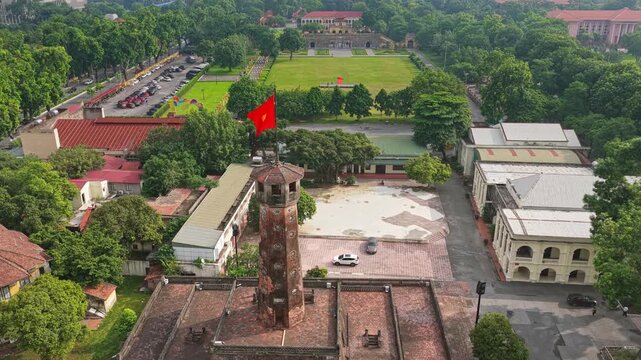 Aerial drone video showing Hanoi Flag Tower, historic architecture, leafy parkland, courtyards, roads, and urban surroundings at the Thang Long Imperial Citadel in Vietnam.