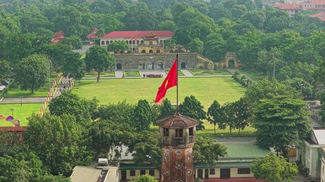 Video of Hanoi Flag Tower flying the Vietnamese national flag, surrounded by lush greenery and historic architecture at the Thang Long Imperial Citadel.