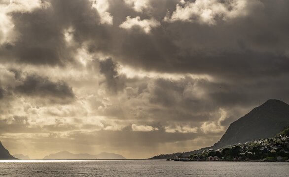 Dramatic lighting and dark clouds over the sea, islands, near &Aring;lesund or Alesund, M&oslash;re og Romsdal county, Norway