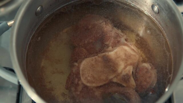 Beef marrow bone simmering in a pot of hot water