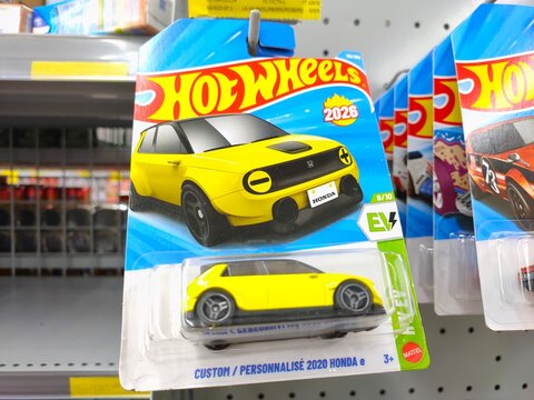 Malang, Indonesia - July 18, 2026: A yellow Hot Wheels "Custom 2020 Honda e" die-cast toy car in its original blister card packaging hanging on a store rack.