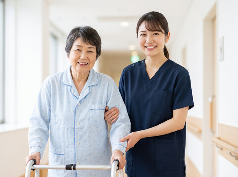 女性医療スタッフと歩行車を両手で握る笑顔の患者
