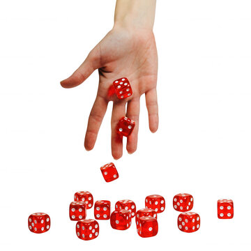 Hand holding red dice mid-air with scattered dice below on white isolated background for gambling or luck concept
