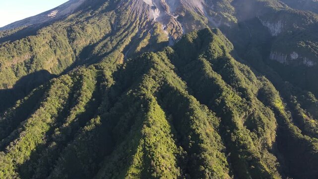 Scenic Aerial Footage of Merapi Volcano with Lush Tropical Forested Slopes During Morning Under a Clear Sky, Vibrant and Wonderful Mountain Scenery of Volcanic Landscape in Yogyakarta, Indonesia.