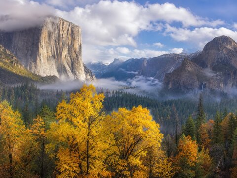 Spektakul&auml;re Herbstlandschaft im Yosemite Nationalpark in Kalifornien mit markanten Granitfelsen, goldenem Laub, Wald und tief liegenden Wolken im Gebirgstal.