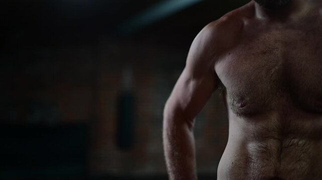 Dark lit gym 120 frames per second video, man in shape shadow boxing, soft focus b roll video, background bokeh, boxing mma workout