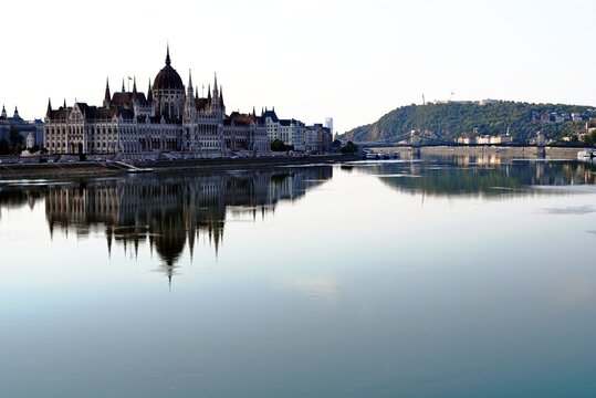 the Hungarian Parliament along the Danube river. Neo Gothic style. panoramic landscape view. reflection on the calm water. tourism and travel concept. popular european destination. 
