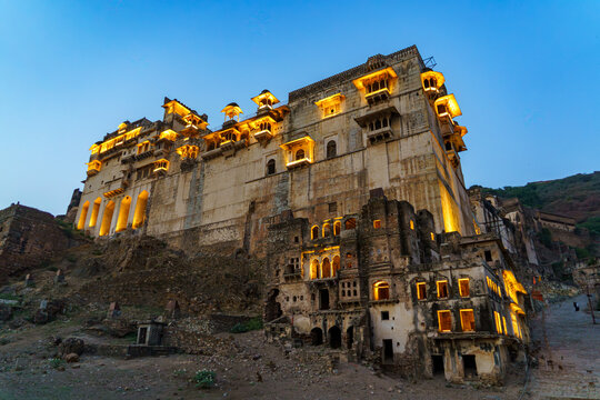 India. Rajasthan. Bundi. Bundi Palace (Garh Palace), illuminated at dusk on its rocky outcrop overlooking the city.