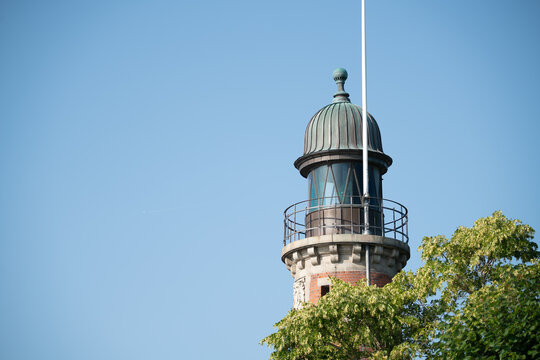 Historic Lighthouse Tower with Blue Sky and Trees