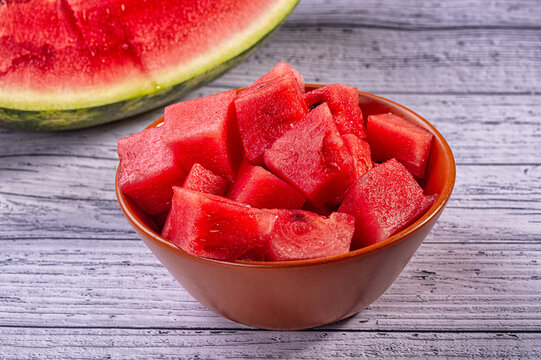Bowl of fresh cubed watermelon on a rustic wooden table