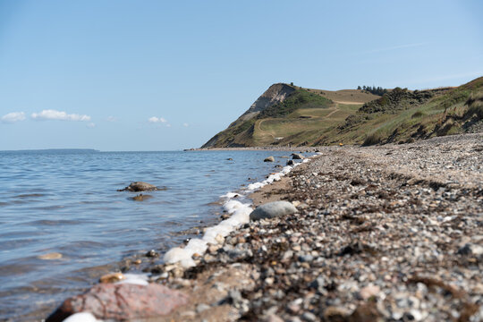 Coastal rocky shoreline with sea waves and grassy headland