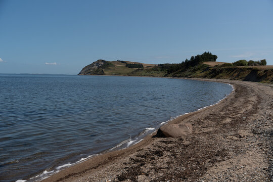 Tranquil coastal shoreline with rocky beach and distant headland