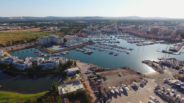 High angle aerial perspective showing the vilamoura marina in the algarve region of portugal, a luxurious tourist destination filled with yachts, hotels, and a beautiful cityscape