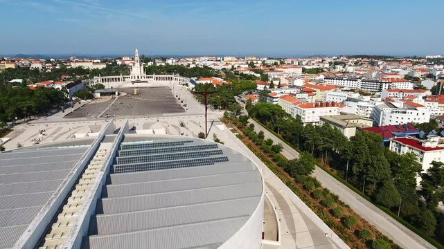Aerial drone footage capturing the vast plaza and surrounding cityscape of the sanctuary of fatima, a famous catholic pilgrimage site with its prominent basilica of our lady of the rosary