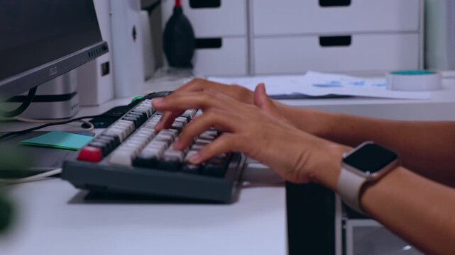 Hand keyboard typing at desk with smartwatch on wrist in office technology work using computer mechanical keys for productivity communication modern workspace close up view