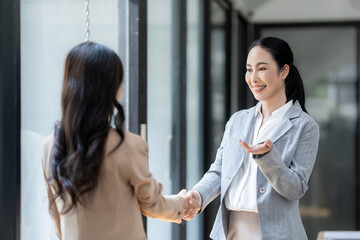 Businesswomen shaking hands in a professional office setting