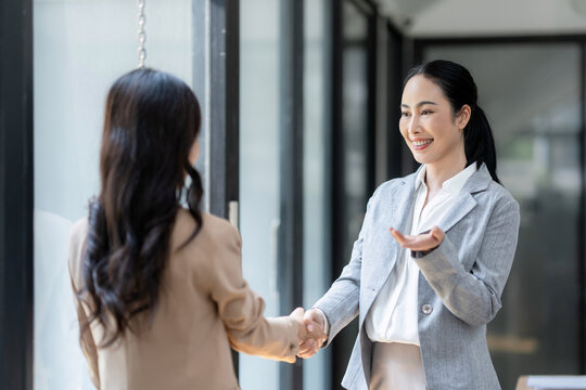 Businesswomen shaking hands in a professional office setting