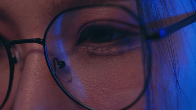 Eye glasses face woman closeup portrait reflection blue light skin calm expression eyelash lens frame detail moody low lighting intimate modern portrait texture human eye behind eyeglass frame