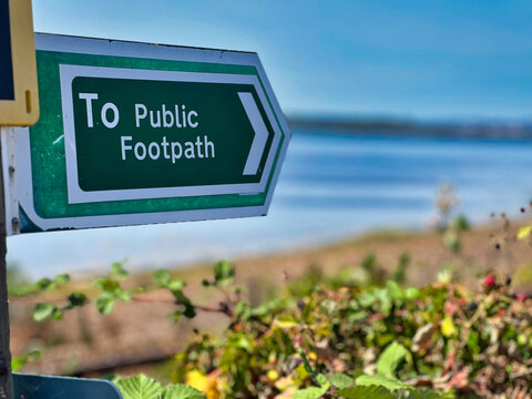 Green Public Footpath Sign with Arrow Along Coastal Walking Trail in Devon, UK