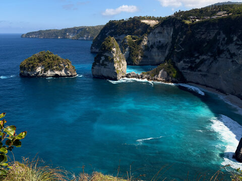 A scenic coastal view featuring rugged cliffs and clear blue waters. Diamond beach in Nusa penida, Bali