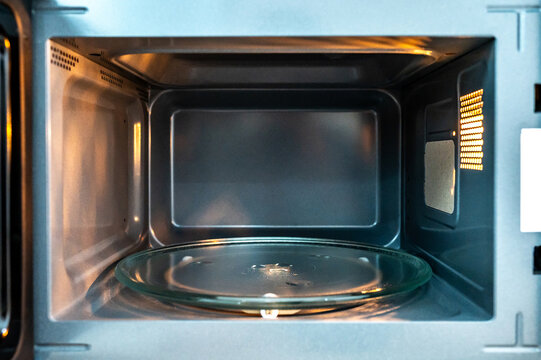 Empty microwave oven with open door. Inside of a modern microwave. Home appliance in the kitchen