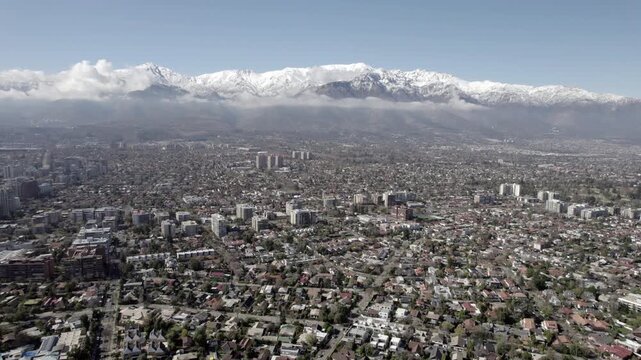 Drone Pull Back Shot Revealing Santiago Cityscape And Snowy Andes Mountains 