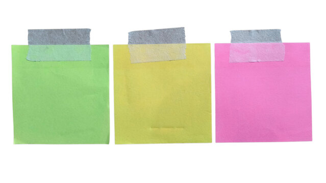 Three colorful square sticky notes in green yellow and pink colors attached with grey masking tape strips for office reminders and organization tasks for school and business projects