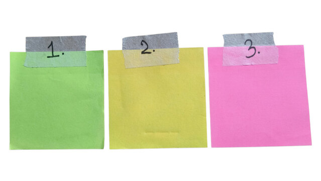 Three colorful sticky notes with numbers one two and three written on them attached with grey tape for organizing tasks reminders and planning office work on a flat surface