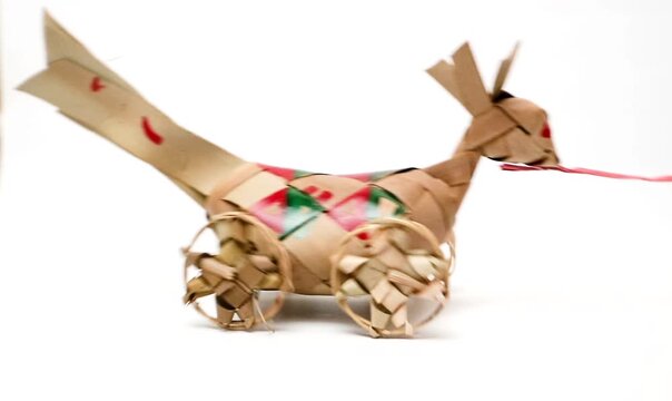 Handcrafted Traditional Bird Toy on Wheels Being Pulled by a Red String over a Clean White Background