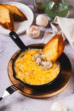 Mushroom julienne with cream and cheese crust in a frying pan on the table vertical view