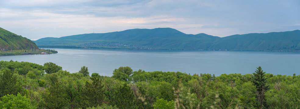 Panoramic view of beautiful Lake Sevan in Armenia with green forest and mountains with copy space